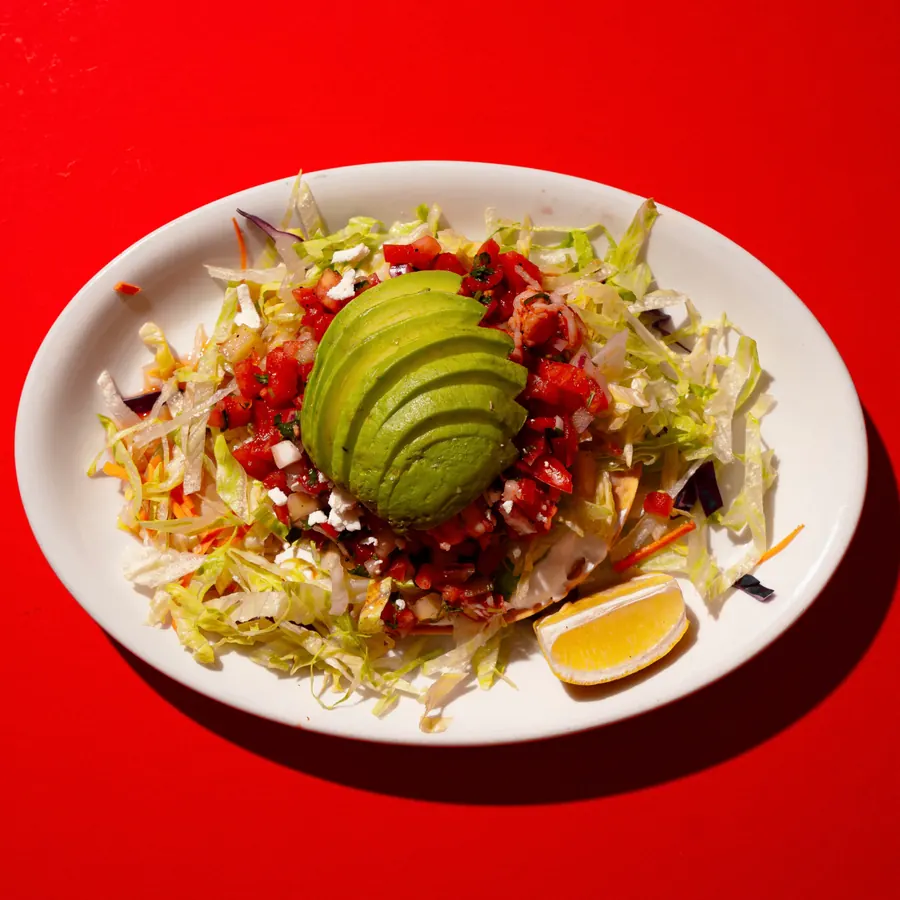 Shrimp tostada salad topped with avocado and pico de gallo