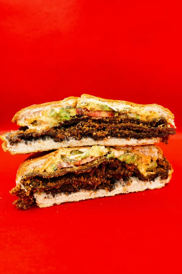 Torta de milanesa stacked and cut open on telera bread